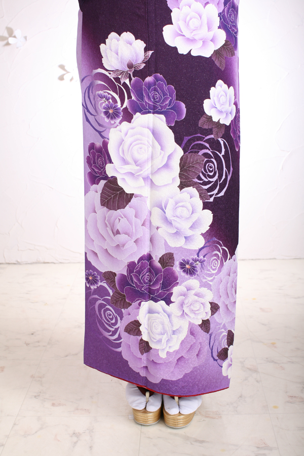 濃い紫の地色に鶴や手まり、桜や椿の花柄が施された上品な振り袖です